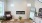 A fireplace in a living room with bright sunshine luxury finishes art large windows