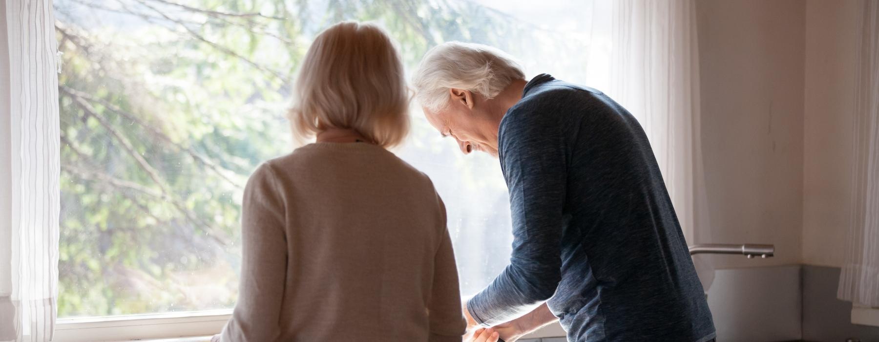 a woman and a man standing in a kitchen